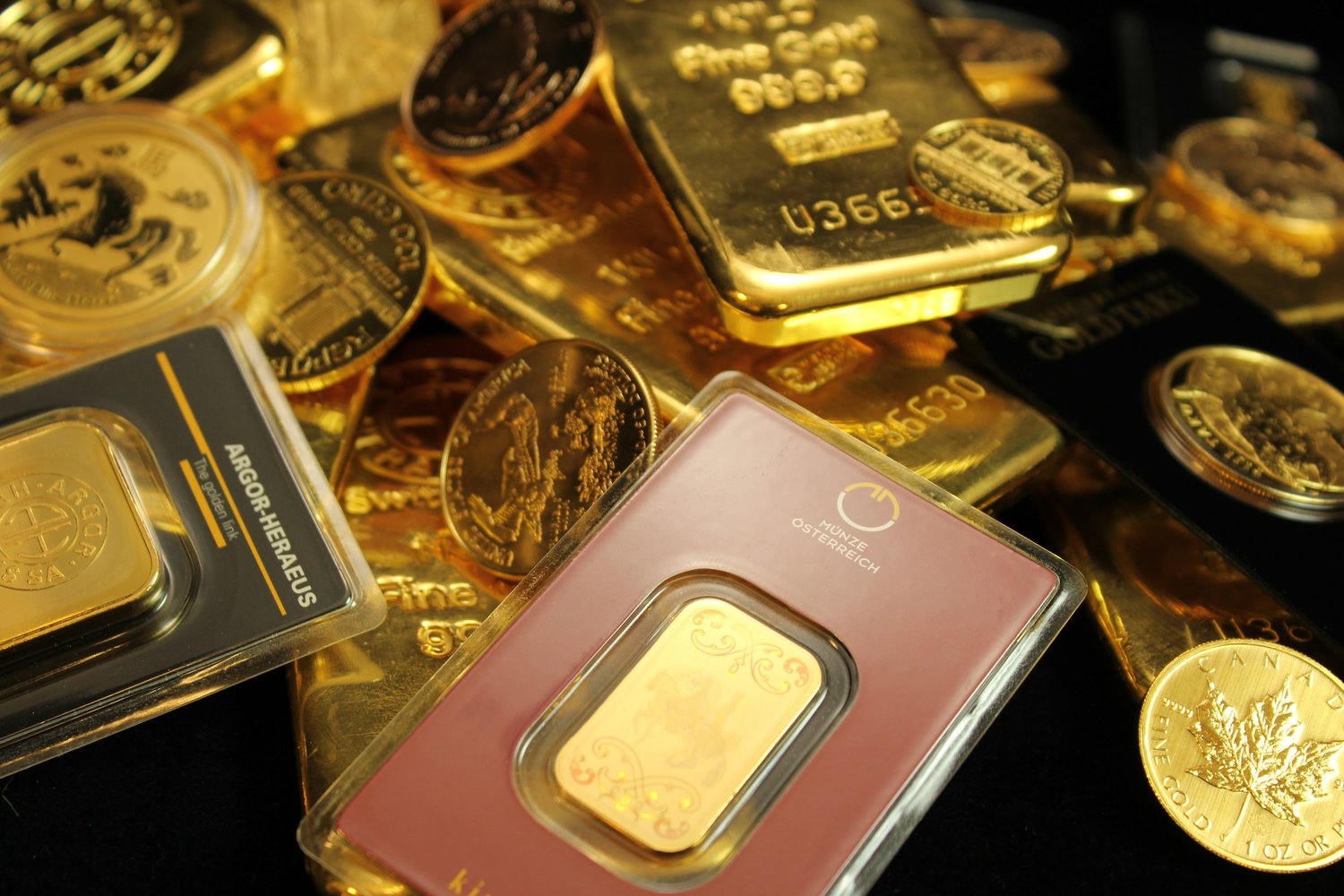 Closeup of various gold coins and bars on a silk display mat.