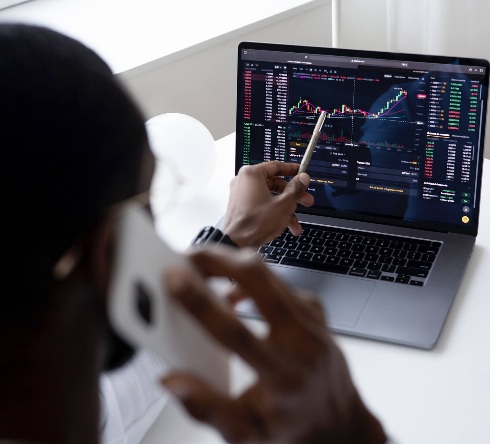 Man pointing at laptop computer screen that contains financial performance data