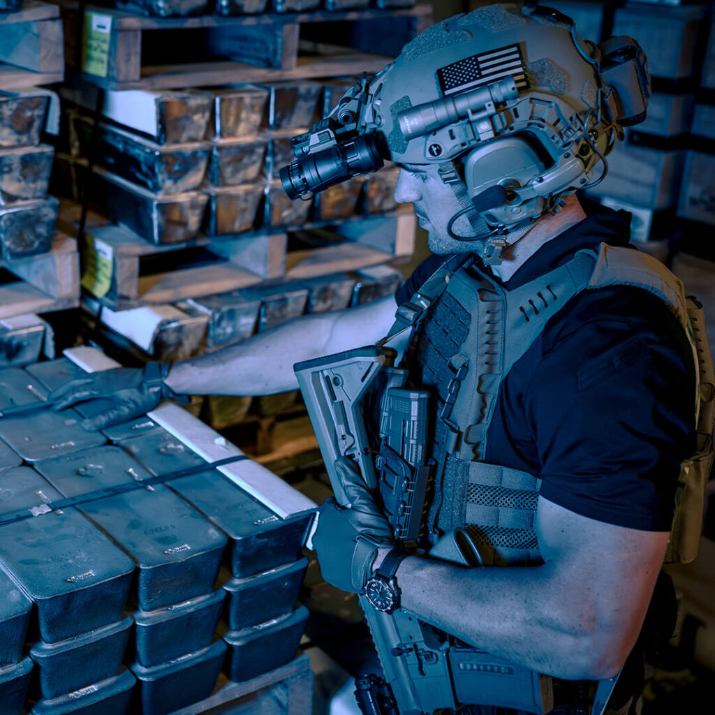 Armed security member rests their hand on 15 kilo silver bars